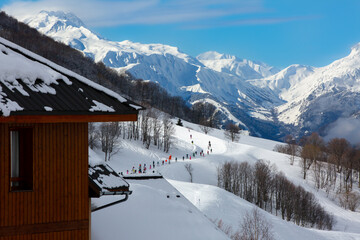 Landscape of mountains with view on one of pistes in Alps, France , with  skiers