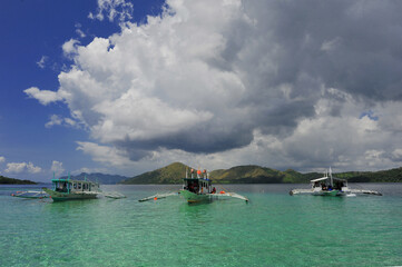Fototapeta na wymiar Banca (Philippines traditional outrigger boat) tourist boats on turquoise water. 