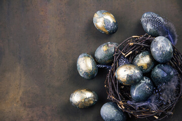 Easter card with a copy of the place for the text. Purple, blue and golden eggs on a dark background. The color trends of 2022  very peri. Natural dye Top view.