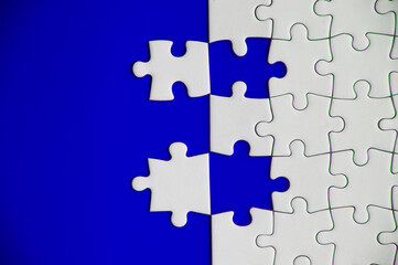 Obraz premium Top view of separated jigsaw puzzle on blue cover background. Copy spave