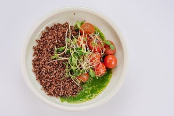Dietary dish with quinoa, cherry tomatoes, spinach sauce and microgreen