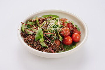Dietary dish with quinoa, cherry tomatoes, spinach sauce and microgreen