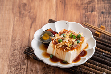 Delicious Chilled tofu and century egg with soy sauce and bonito flakes.