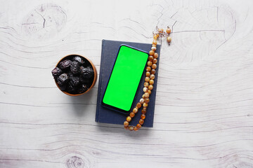 smart phone, Holy book Quran and rosary on table, 