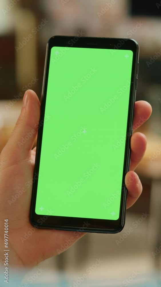 Poster Vertical Screen: Hand Scrolling Feed on Smartphone with Green Screen Mock Up Display. Person Resting at Home and Checking Social Media on Mobile Device. Close Up Over the Shoulder Footage.