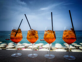 cztery kolorowe drinki na tle plaży i morza.