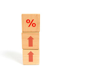 Concept of financial and mortgage interest rates. Wooden cube block increasing from above with icon percent symbol up.