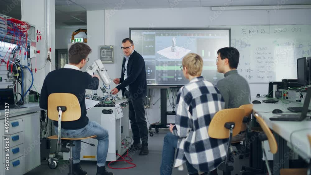 Poster Male Teacher Showing Details of Robot Arm and Brainstorming with Students at University Robotics Class. Diverse Group of Young Engineers Sitting at University. Computer Science Education and Learning