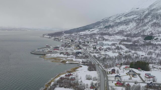 Scenic town of Olderdalen on banks of Kaafjord, snowy landscape; aerial