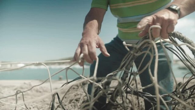 Local fisherman working with fishing nets at sea shore, cinematic shot
