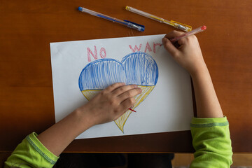 Ukrainian flag and a heart in yellow and blue color. Child draws a heart on the blackboard