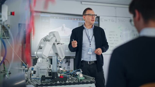 Male Teacher Showing Details and Having Lesson with Students at University Robotics Class at University. Computer Science Education and Machine Learning; Robot Arm Concept