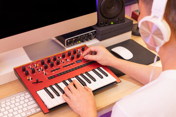 Male professional music producer hands playing synthesizer keyboard for recording and arranging a...