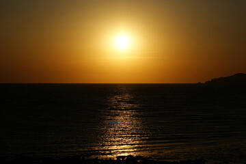 The golden sunset is reflected in the sea.