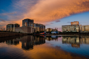 Fototapeta premium MOSCOW, RUSSIA - AUGUST 5, 2018: View of modern buildings near the water during sunset