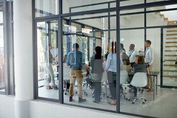 Getting things going in the boardroom. Full length shot of a business meeting taking place in a...