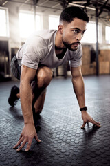 Theres no secret formula. Shot of a sporty young man stretching his legs while exercising in a gym.