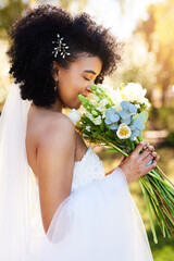 The sweet smell of love and happiness. Shot of a happy and beautiful young bride smelling her...