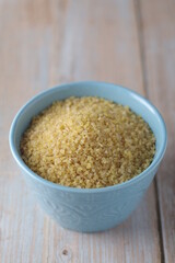 Dry uncooked bulgur in a ceramic bowl	