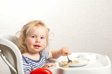 feeds baby boy with a spoon porridge