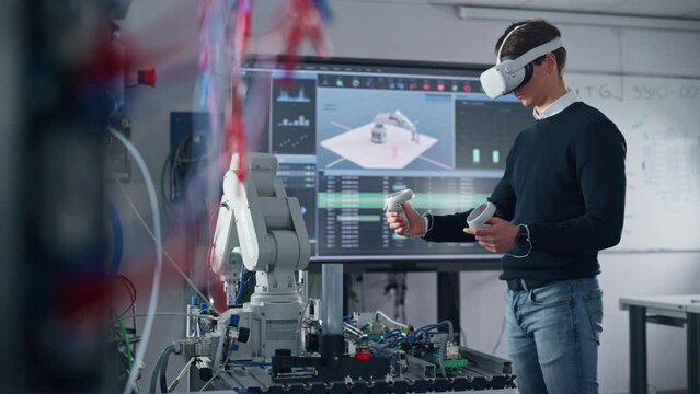 Student Engineer Wearing Virtual Reality Headset Holding Controllers and Moving Bionic Claw Under his Control During the Lesson. University with Modern Equipment. Computer Science Education Concept
