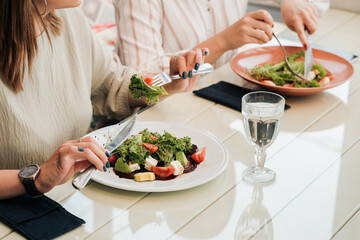 Close Up of Unrecognisable Women Having Lunch Meeting, Eating Salad in the Restaurant 