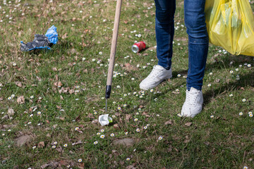 Close up of man collecting garbage with stick as a tool in the park with flowers © NOWRA photography