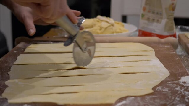 Horizontal slicing polish faworki dough sheets during Tlusty Czwartek