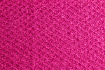Lilac-pink knitted carpet close-up. Textile texture on a lilac-pink background. Detailed warm yarn background. Natural wool fabric, sweater fragment.