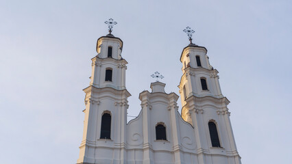 Catholic cathedral in Baroque style against the sky. An old tall building with two towers.