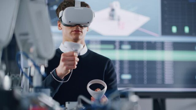 Male Student in VR Googles Lifting and Moving Bionic Hand wit Controllers while Doing his Project at the University. Computer Science and Education Concept