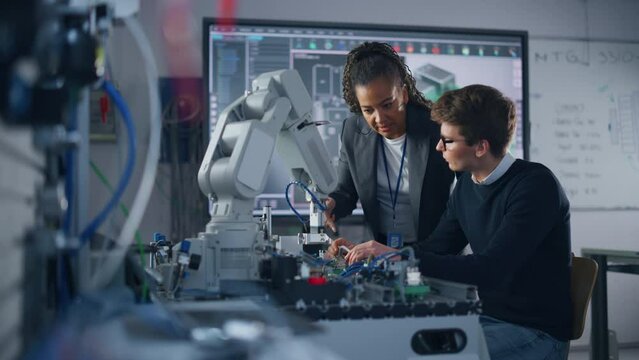 Male Student Engineer Discussing Ideas with Black Teacher while Working with Computer Processor. Man Uses Screwdriver. High-Tech Science and Engineering Concept. Medium Shot