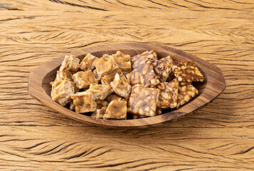 Pe de moleque, typical brazilian peanut candy over wooden table. June festival food