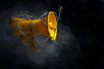 megaphone wrapped in barbed wire. the concept of banning freedom of speech. censorship barbed wire...