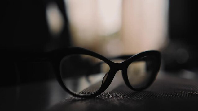 The man picks up the glasses lying on the table. Cool close-up