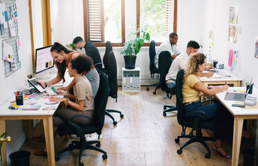 A small office filled with big dreams. Shot of a group of young businesspeople working together modern office.