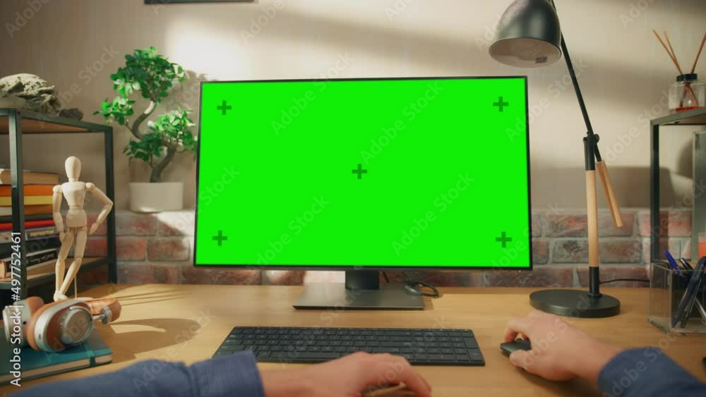 Poster POV First Person View of a Man Working on Desktop Computer with Green Screen Mock Up Display. Male Sitting at a Desk, Browsing Internet and Using Mouse at Home in Stylish Living Room.