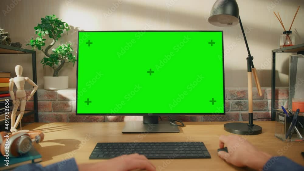 Aufkleber POV First Person View of a Man Working on Desktop Computer with Green Screen Mock Up Display. Male Sitting at a Desk, Typing on Keyboard and Using Mouse at Home in Stylish Living Room.