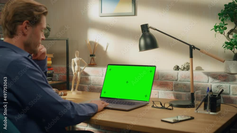 Aufkleber young handsome man working from home on laptop computer with green screen mock up display. creative 
