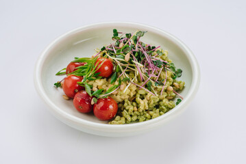 Pearl barley dish with cherry tomatoes and microgreens. Diet menu