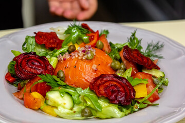 Salad with salmon, cucumbers, tomatoes and beets