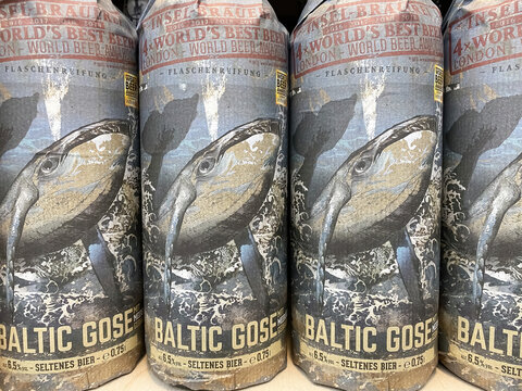 Viersen, Germany - April 5. 2022: Closeup of baltic gose craft beer bottles wrapped in artful paper in shelf from german island brewery