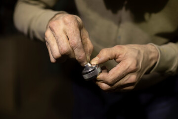 Fototapeta premium Valve from spray gun in hands. Repair parts of paint remote. Cleaning valve.