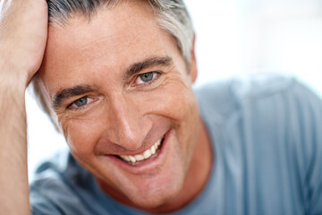 Being at home makes me so happy. Headshot portrait of a handsome mature man smiling while looking at the camera during the day.
