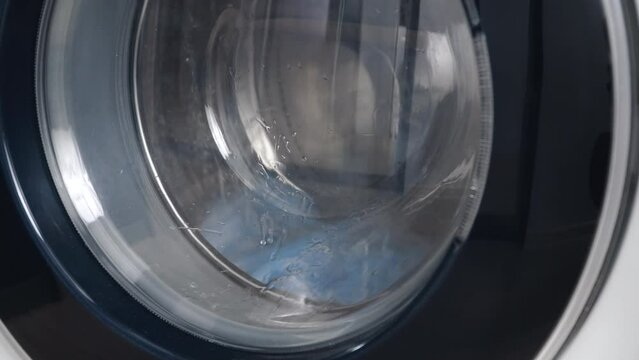 Washing machine washes dirty medical masks. Close up video of spinning drum washing machine
