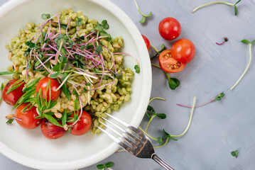 Pearl barley dish with cherry tomatoes and microgreens. Diet menu