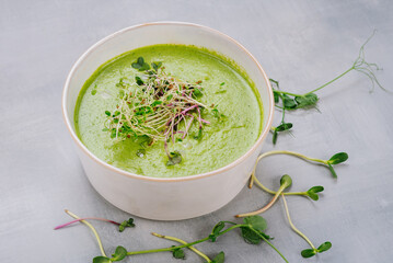Dish of spinach cream soup and greens. Close up