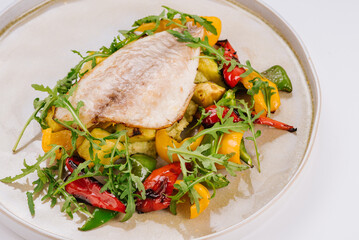 White fish dish with cherry tomatoes, lettuce, microgreens and sesame seeds