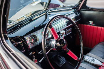 Fototapeta premium Classic car interior with steering wheel and chrome dash with leather seats