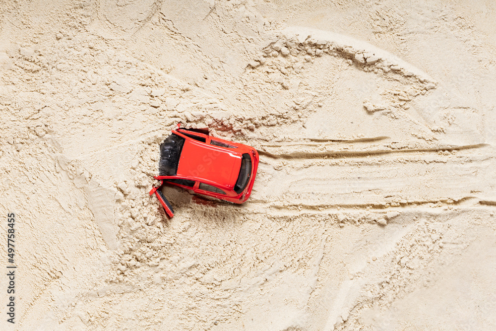 Wall mural red toy car dug in the sand, quicksand. wheel tracks in the sand. difficult situation